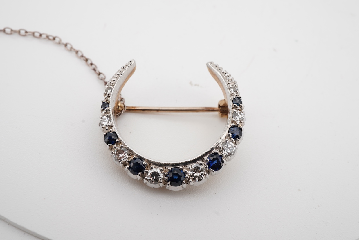 A 1970's Edwardian style 9ct gold, graduated sapphire and diamond set crescent brooch, 24mm.